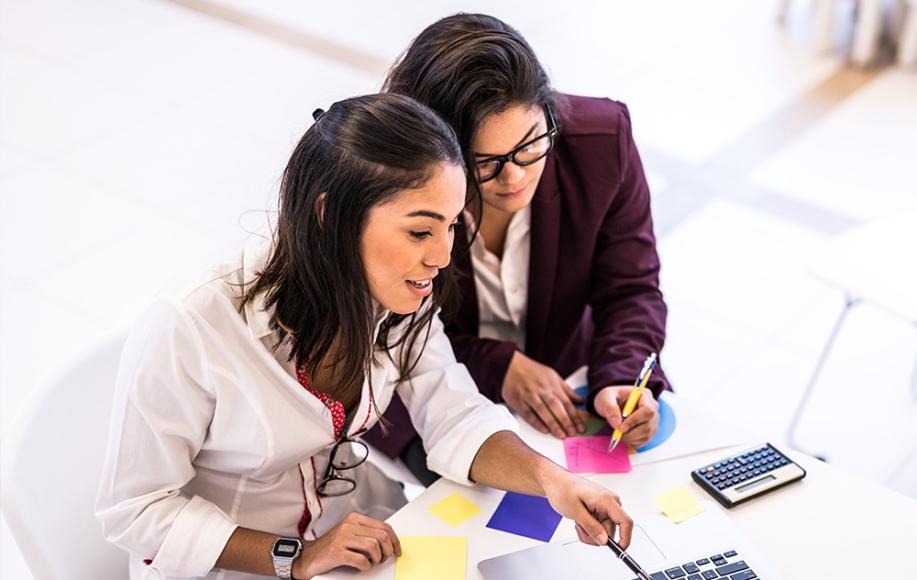 Two business students working together on laptop